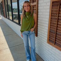 Solid sleeveless mock neck top featuring draped front