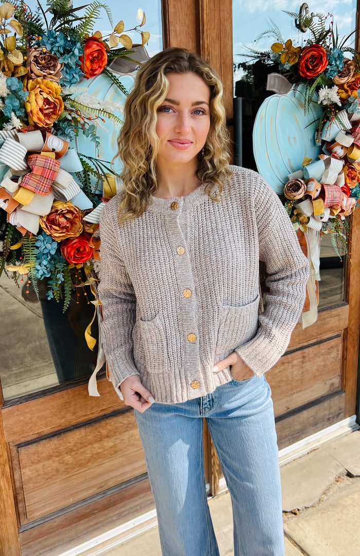 Solid long sleeve cardigan featuring front patch pockets. Button closure at front.