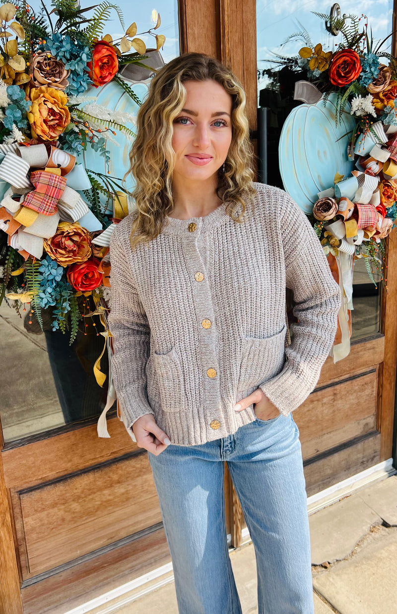 Solid long sleeve cardigan featuring front patch pockets. Button closure at front.