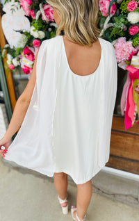 Solid sleeveless mini dress featuring draped cowl neckline with back scarf panel