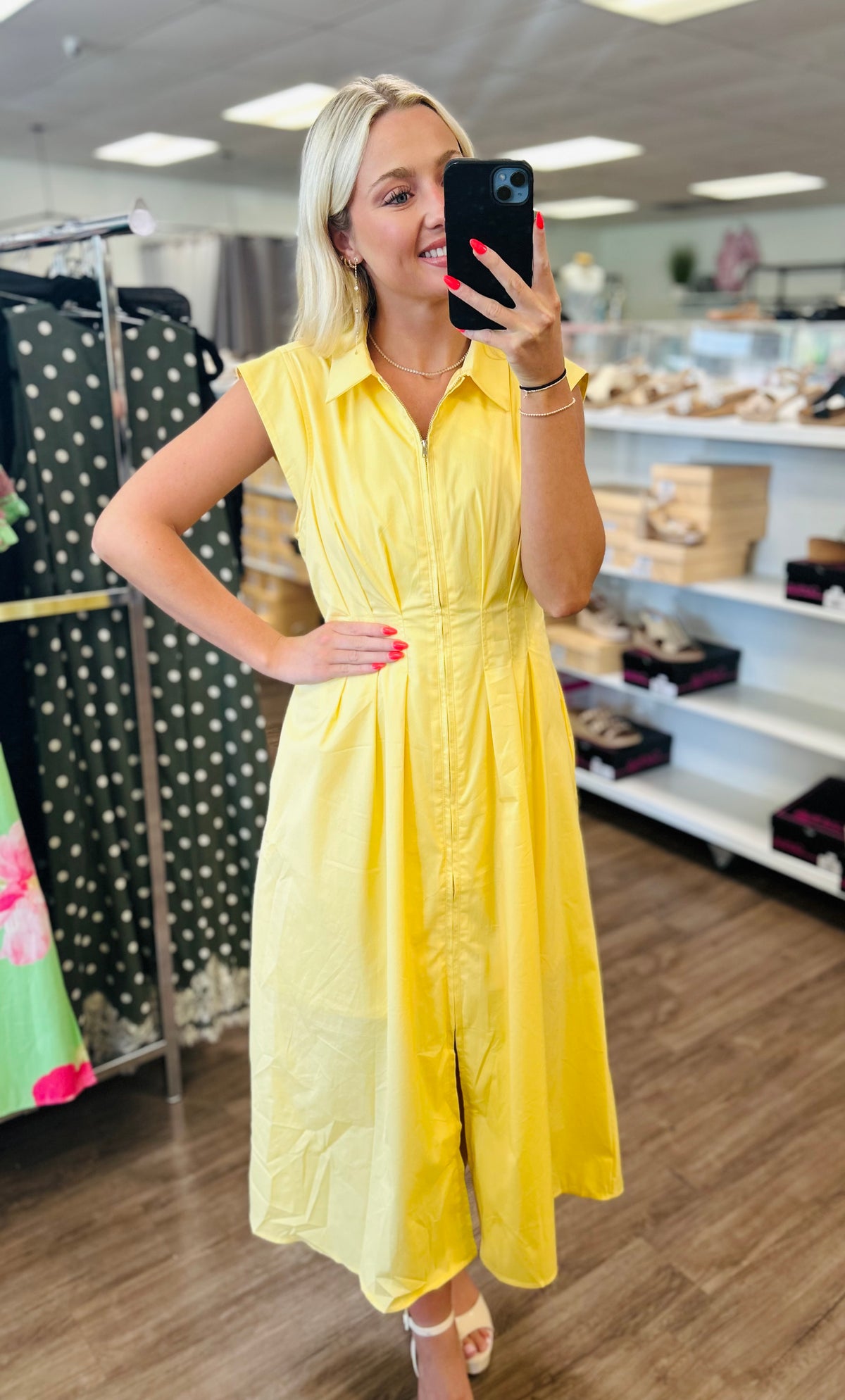 Solid sleeveless midi dress featuring collar and zipper closure at front.