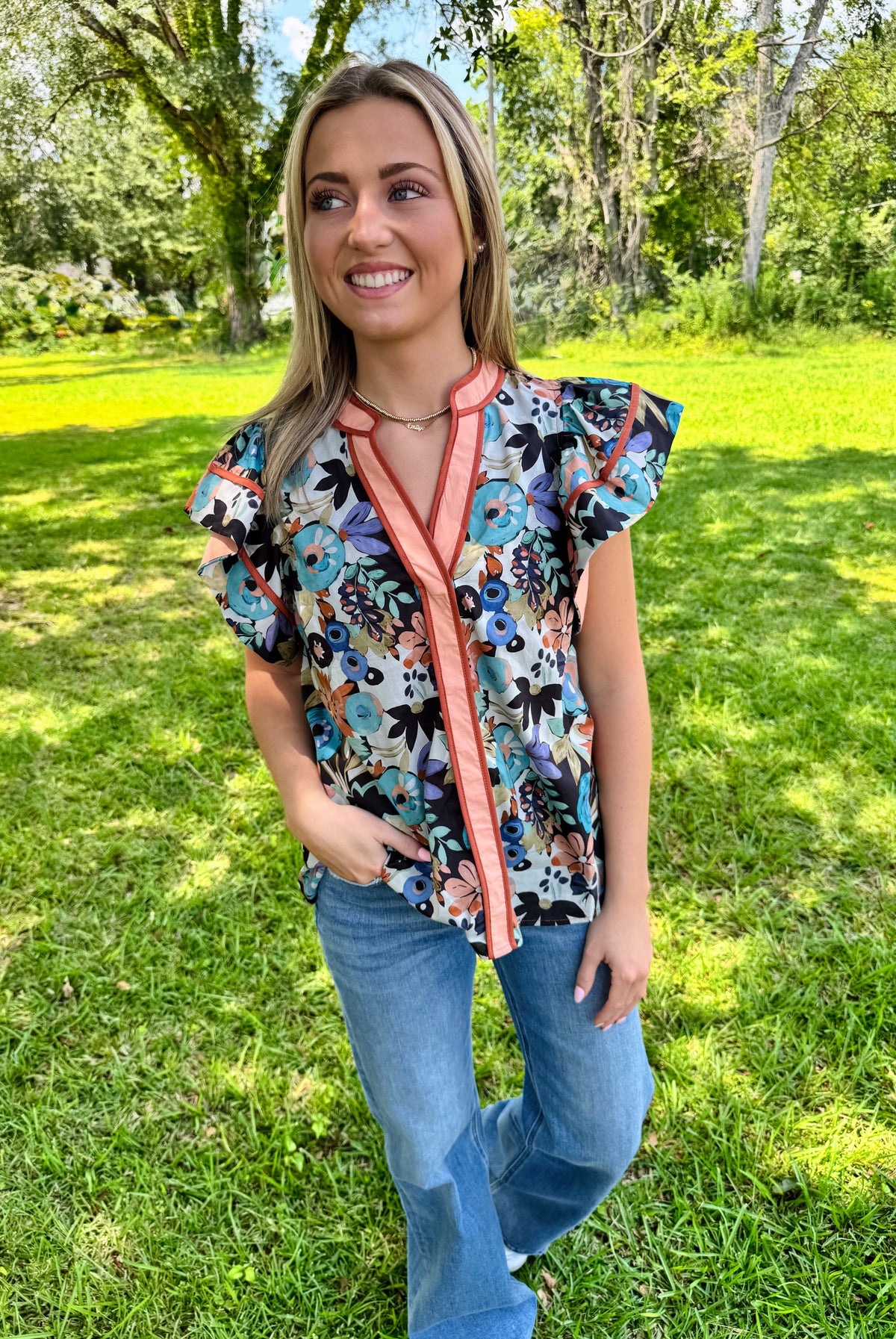Multi-floral print flutter ruffle sleeve featuring contrast accent V-neck band