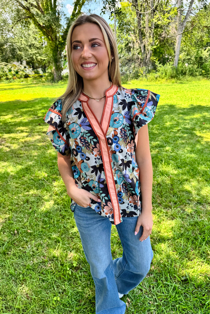 Multi-floral print flutter ruffle sleeve featuring contrast accent V-neck band