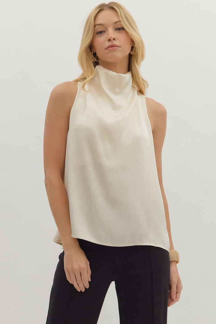 Solid sleeveless mock neck top featuring draped front