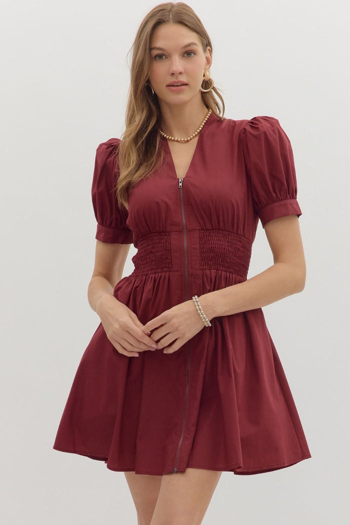Solid short puff sleeve V-neck mini dress featuring smocked waist front-zip closure.