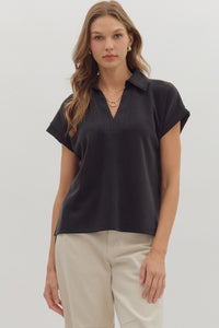 Solid cuffed short sleeve top featuring collared V-neck.