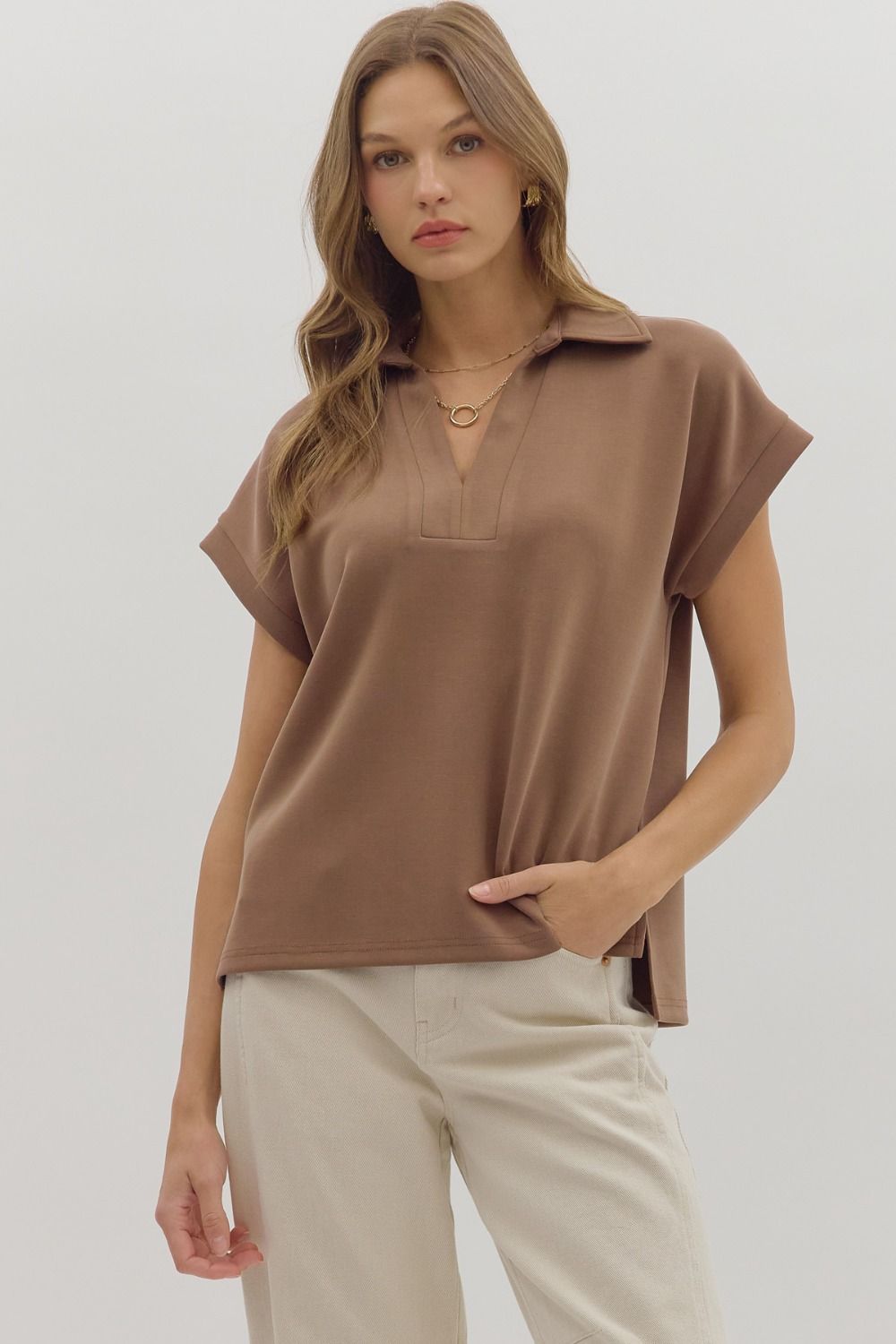 Solid cuffed short sleeve top featuring collared V-neck.