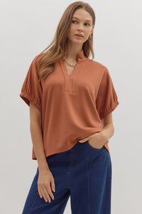 Solid short sleeve top featuring split V-neck with collar band