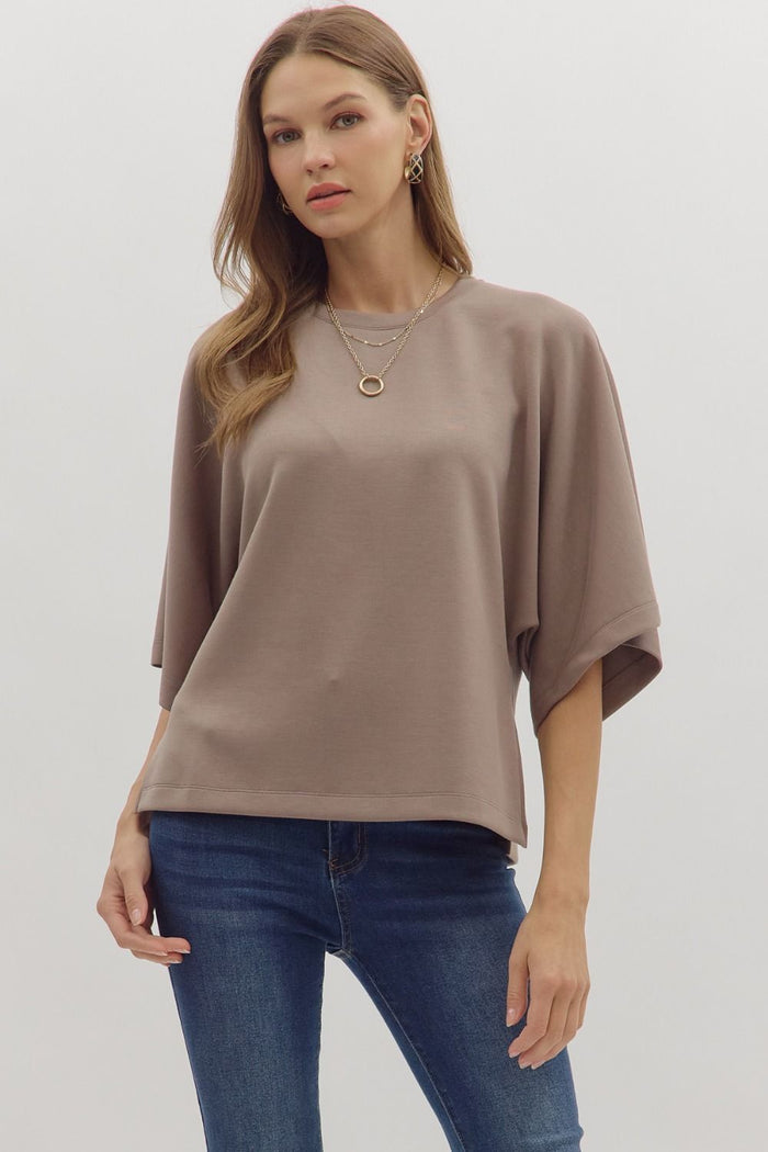 Solid elbow sleeve top featuring wide relaxed silhouette