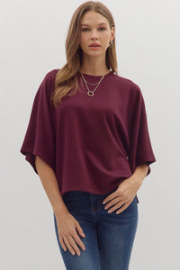 Solid elbow sleeve top featuring wide relaxed silhouette