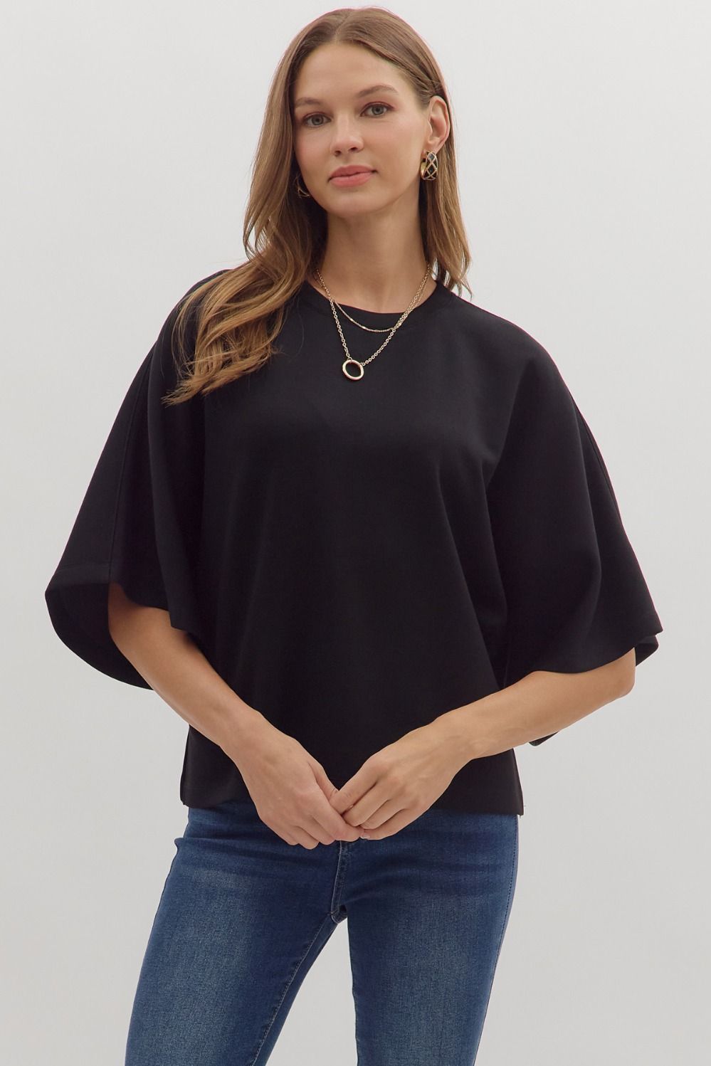 Solid elbow sleeve top featuring wide relaxed silhouette