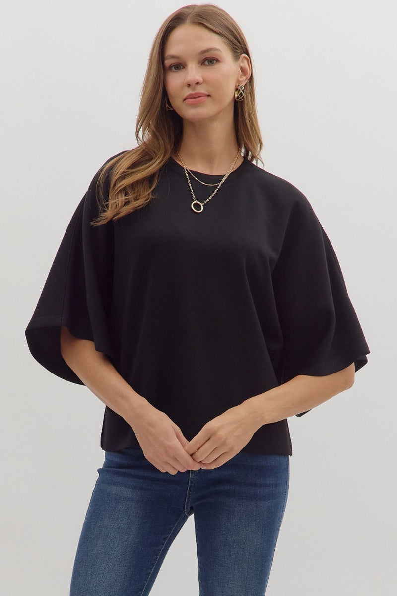 Solid elbow sleeve top featuring wide relaxed silhouette