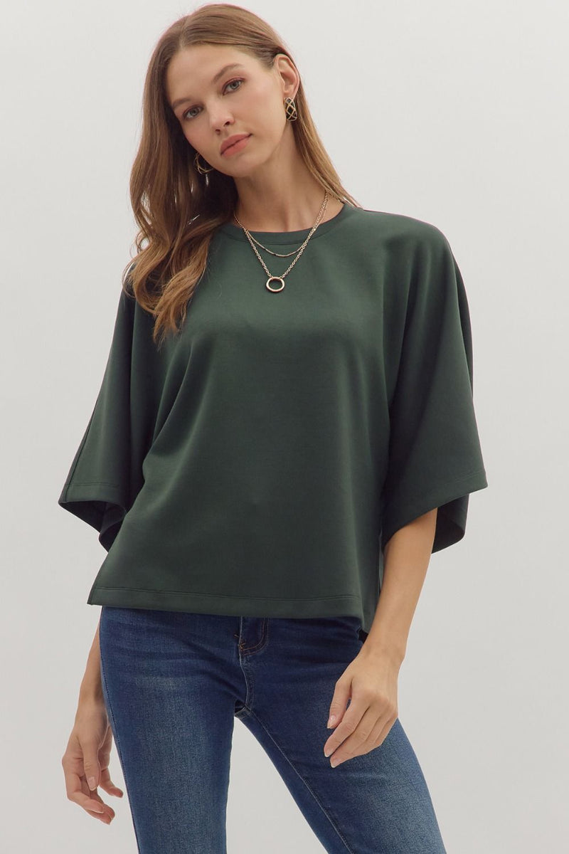 Solid elbow sleeve top featuring wide relaxed silhouette