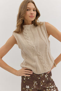 Solid sleeveless mock neck sweater knit top featuring cable knit texture.