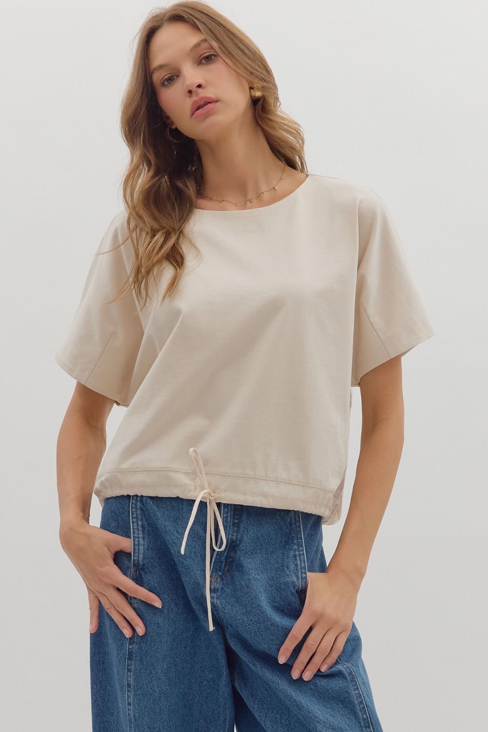 Solid short sleeve round neck top featuring adjustable drawstring hem