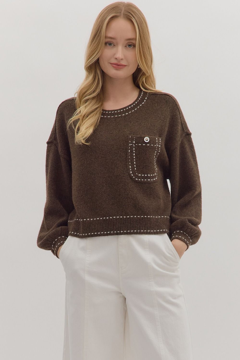 Solid long sleeve sweater knit top featuring contrast blanket stitch accents