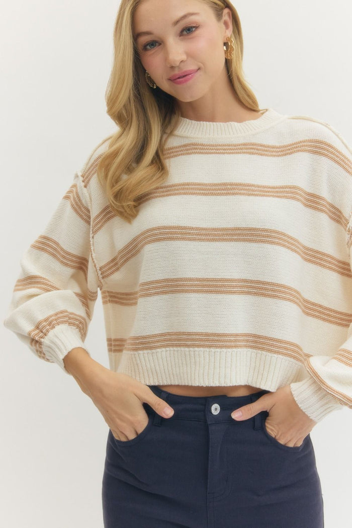 Striped long sleeve knit sweater featuring ribbed neckline, cuffs, and hem