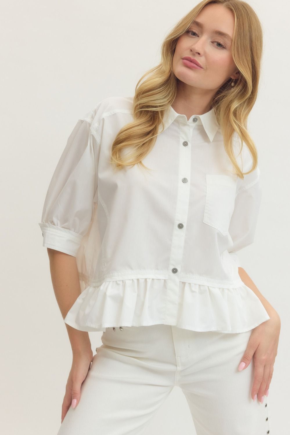 Solid short sleeve button-down top featuring ruffle hem detail