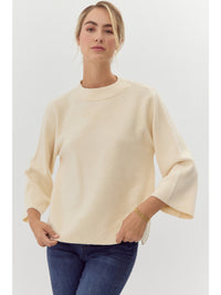 Solid knit pullover top with mock neck, and three quarter bell sleeves.