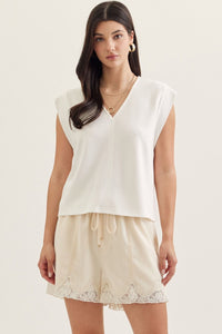 Solid cap sleeve top featuring center front seam detail