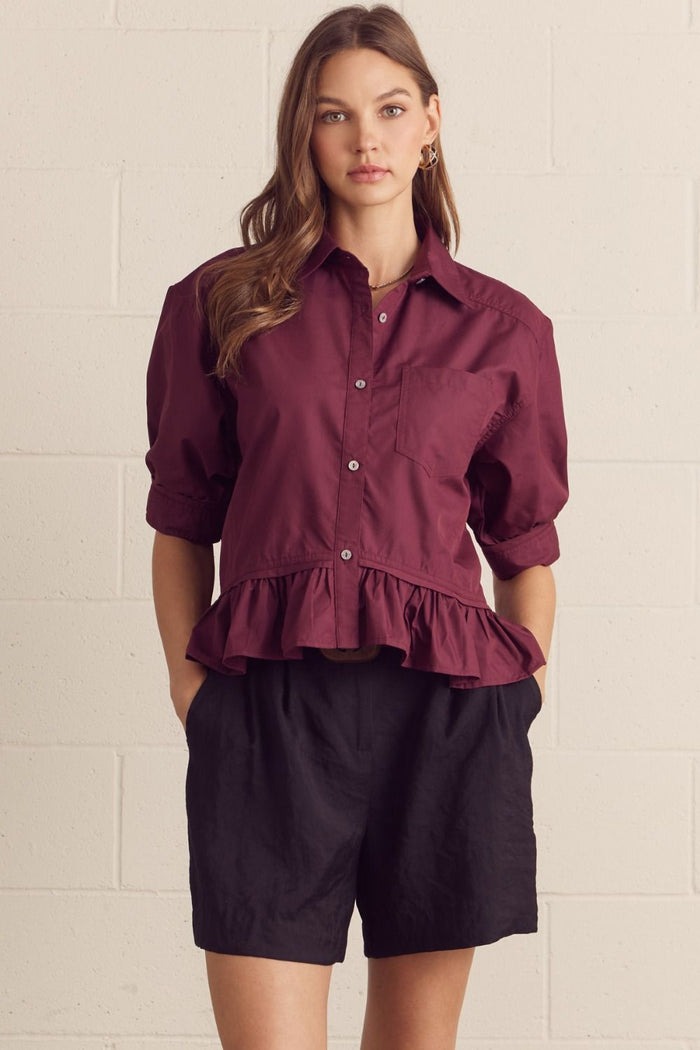 Solid short sleeve button-down top featuring ruffle hem detail