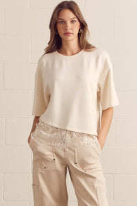 Solid short sleeve knit top featuring scallop lace hem detail.