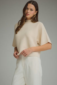 Solid mock neck short sleeve sweater knit top featuring dolman sleeves