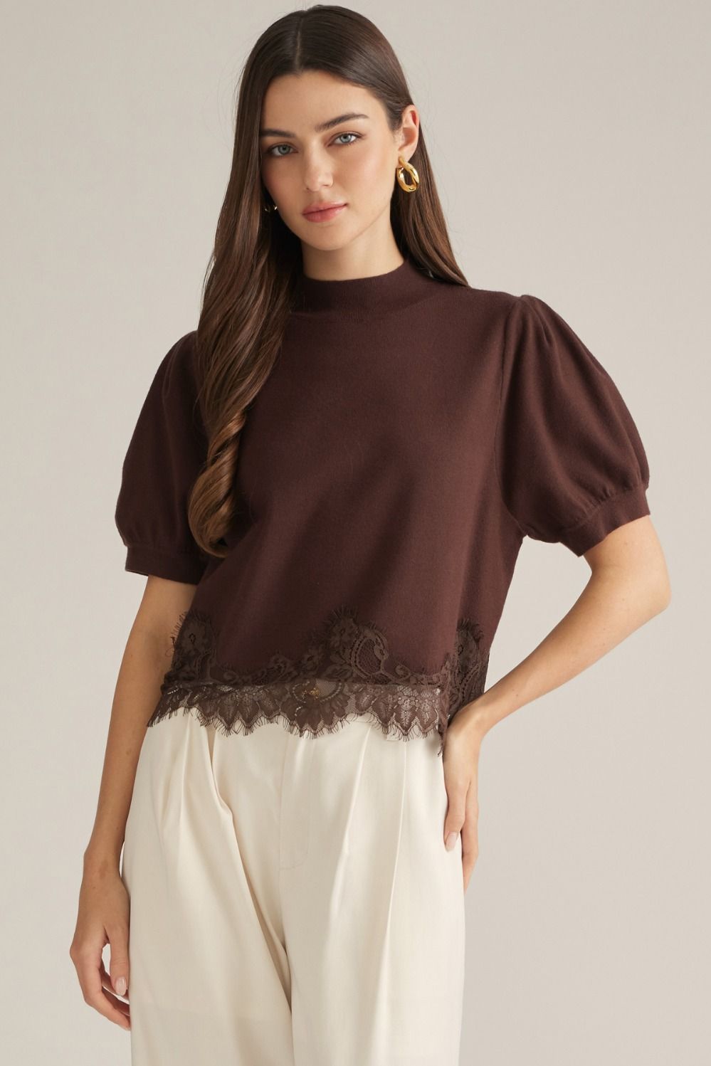 Solid short puff sleeve sweater top with a mock neck. Lace trim detail at hem.