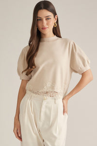 Solid short puff sleeve sweater top with a mock neck. Lace trim detail at hem.