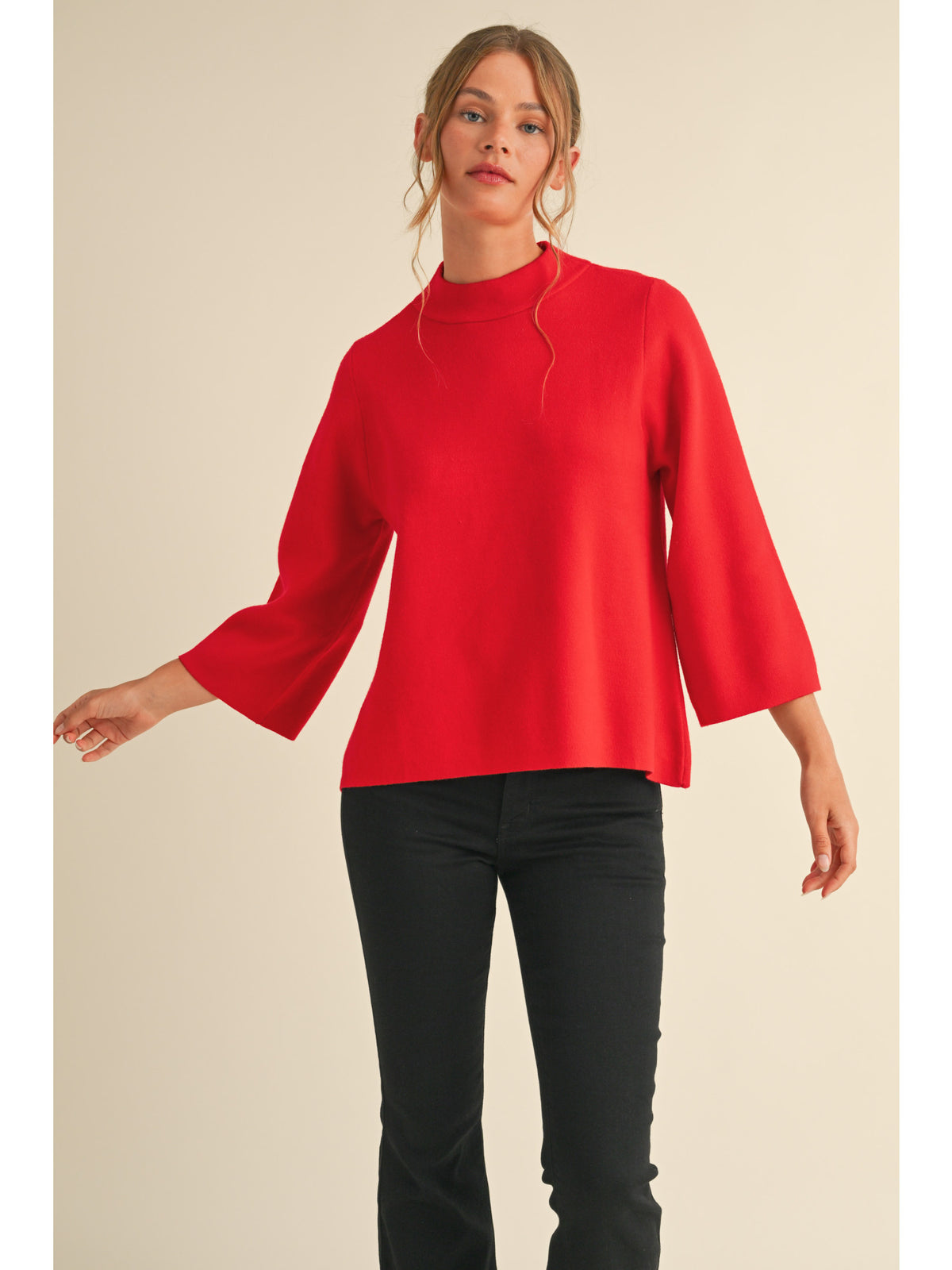 Solid knit pullover top with mock neck, and three quarter bell sleeves.