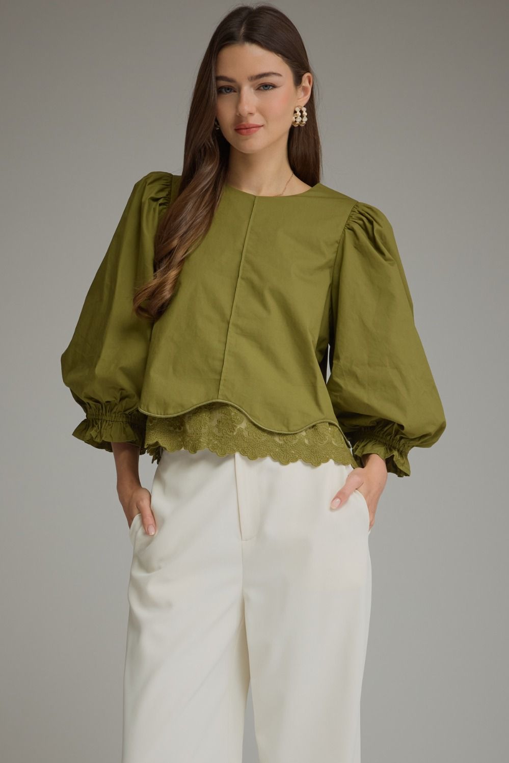 Solid ¾ balloon sleeve top with a round neckline and lace trim detail at hem