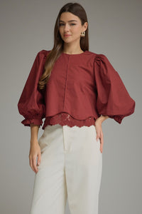 Solid ¾ balloon sleeve top with a round neckline and lace trim detail at hem