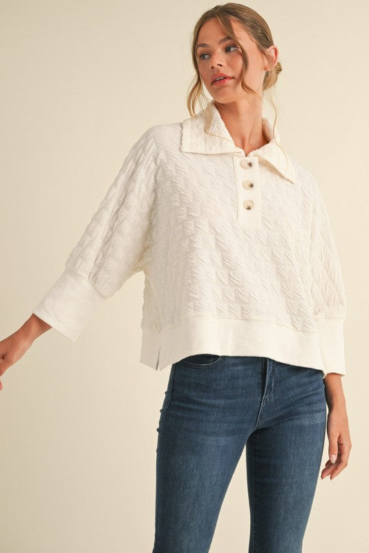 Textured pullover top with buttoned henley collared neck