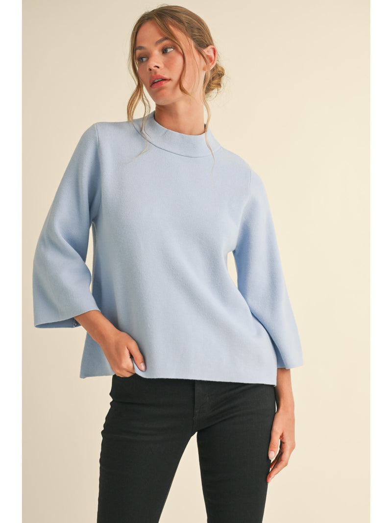 Solid knit pullover top with mock neck, and three quarter bell sleeves.