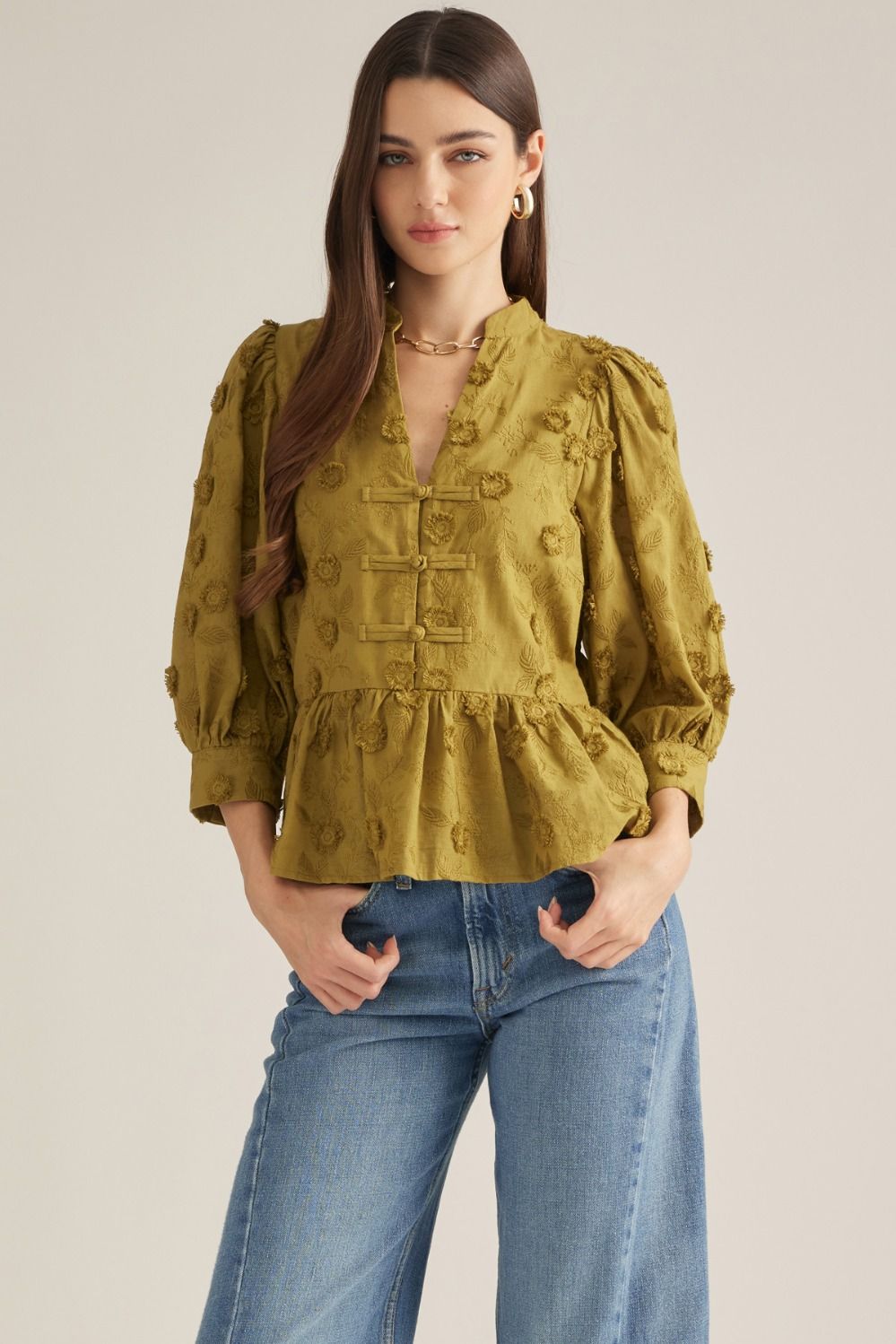 Solid ¾ puff sleeve top . Floral embroidery detail throughout